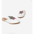 Cheska Floral Embroidered Flat Mule In White Faux Leather, White
